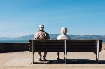 Two people sitting on a bench overlooking mountains in Nevada.