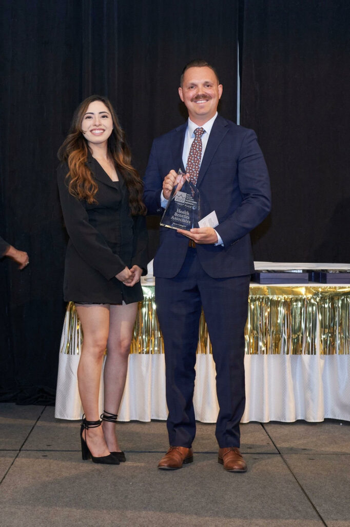 Health Benefits Associates team member holding NNHRA 2023 Best Places to Work award